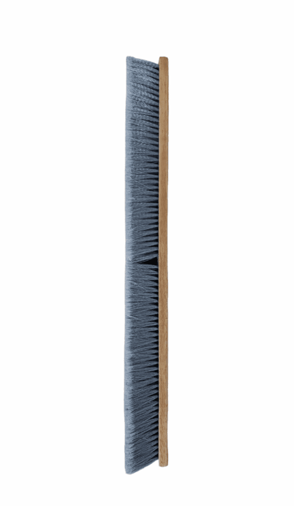 A worn-out wooden broom with gray bristles leaning vertically.